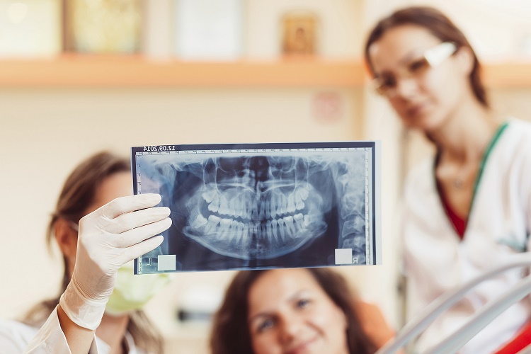 Dentist and patient looking to x-ray