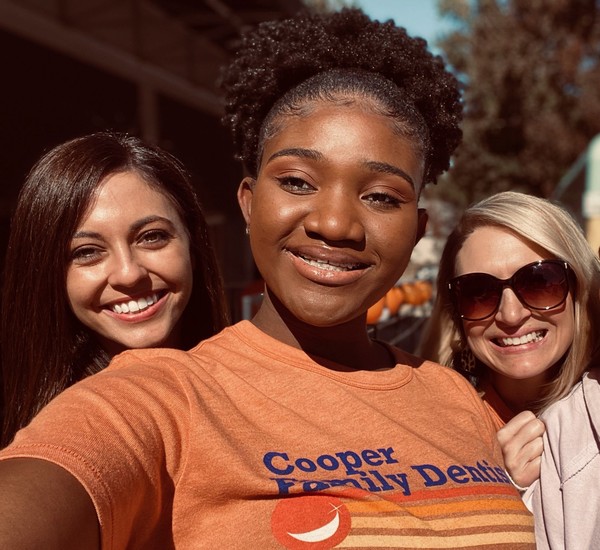 General-Dentistry-Orthodontics-Cooper-Family-Dentistry-Jacksonville, AR-Servicespage-Routine-Dental-Care-Exams Three smiling women posing together outdoors on a sunny day