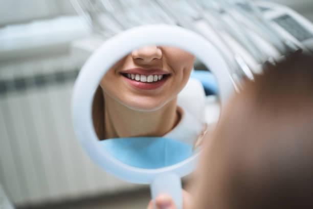 Child smiling at dentist during dental examination in clinical setting.